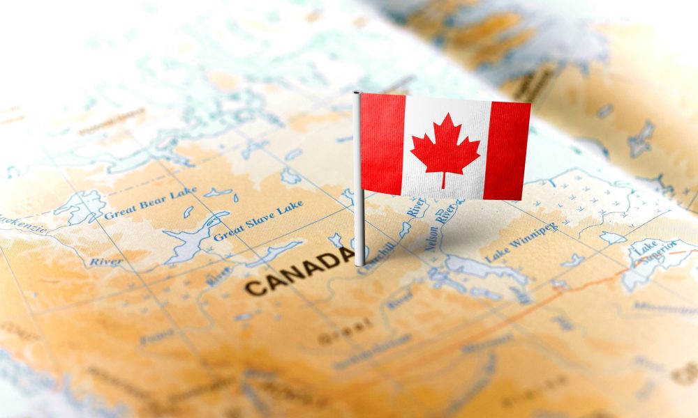 The flag of Canada pinned on the map. Horizontal orientation. Macro photography.
