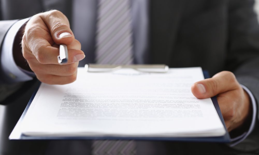 Close-up of businessman propose to sign paper, give silver pen to make deal on document. Prepared business papers for client. Business, success concept