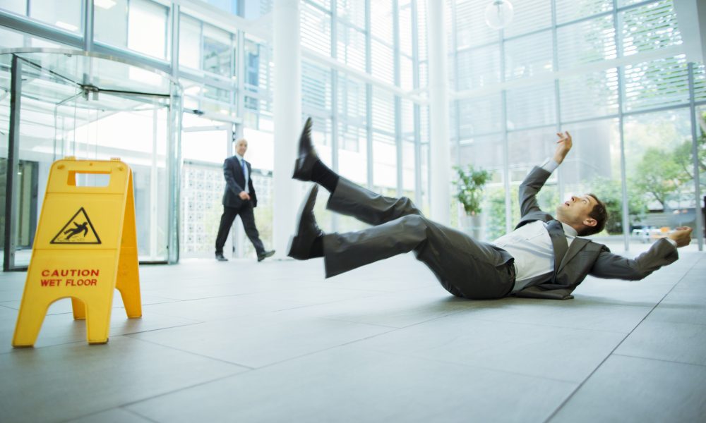 Businessman slipping on floor of office building