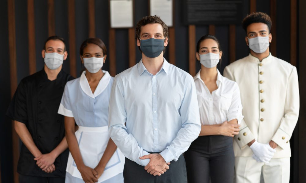 Staff working at a hotel wearing facemasks during the COVID-19 pandemic - reopening of businesses