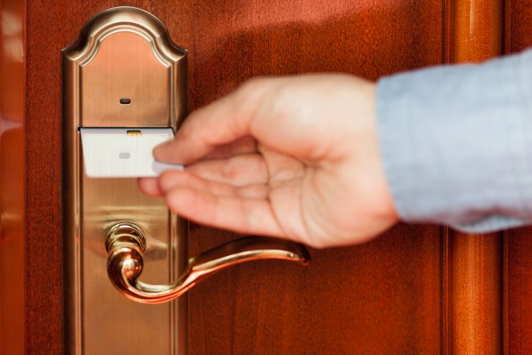 Man using a key card to enter a hotel room.