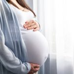 Side view pregnant woman with big belly advanced pregnancy in hands. Banner copyspace for text. Elegant mother waiting baby