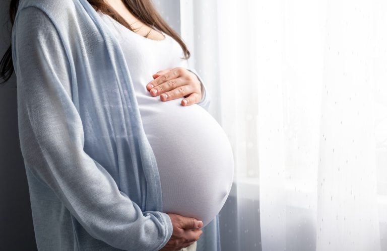 Side view pregnant woman with big belly advanced pregnancy in hands. Banner copyspace for text. Elegant mother waiting baby