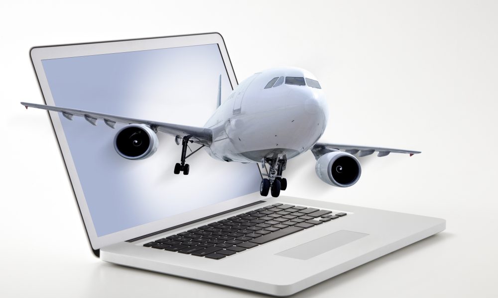 Passenger plane coming out of laptop screen symbolizing online ticketing
