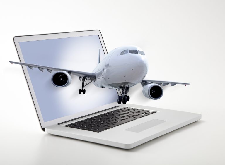 Passenger plane coming out of laptop screen symbolizing online ticketing