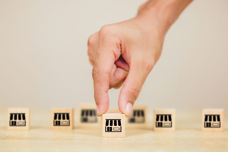Franchise business concept , businessman hand choose wood blog with franchise marketing.
